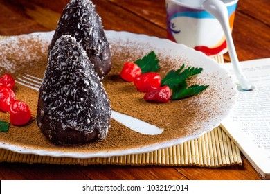 chocolate Cake with red berries and mint on a white saucer filled with cocoa