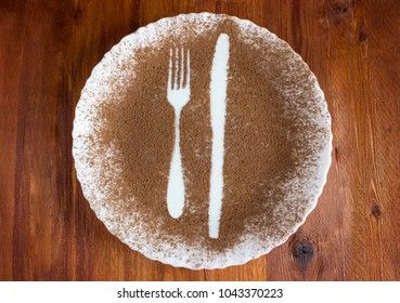shape of a fork and knife on a white plate on a wooden background