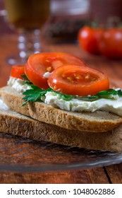 Irish breakfast sandwich with curd cheese, herbs and tomatoes on a background with coffee
