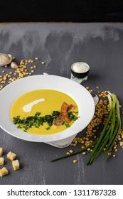 Pea soup with pieces of bacon, parsley and onion in a bowl on a dark background. Pea cream soup.