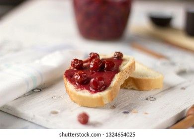 Bread with homemade cherry jam on a light background, closeup