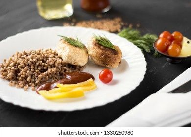 Chicken cutlets with buckwheat, herbs, ketchup and tomatoes