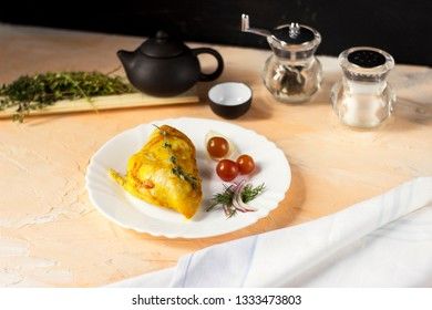 Baked chicken breast with onions and tomatoes on a white plate. Healthy food.