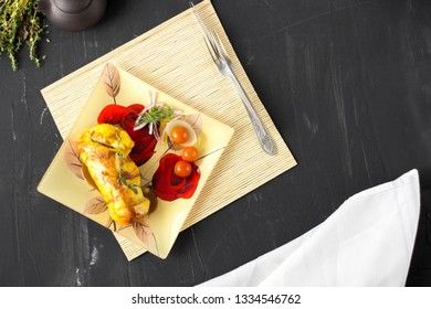 Baked chicken breast with onions and tomatoes on a white plate. Healthy food.