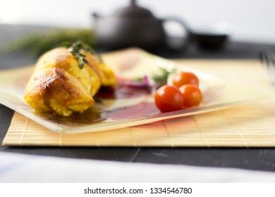Baked chicken breast with onions and tomatoes on a white plate. Healthy food.