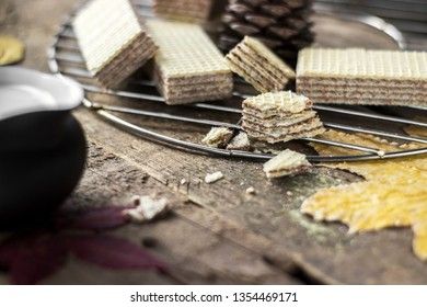 Sweet russian artek waffles on wooden background, with a pot of milk. Traditional sweets and dessert.