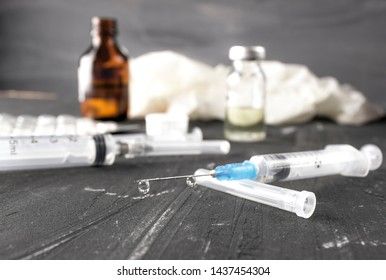 Medical ampoules with vaccine and syringe on gray background. Medical ampoules with pure vaccine and syringe on gray background