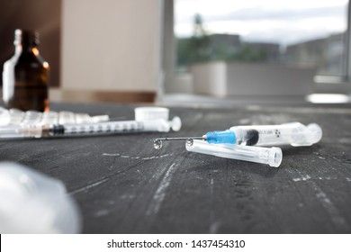 Medical ampoules with vaccine and syringe on gray background. Medical ampoules with pure vaccine and syringe on gray background