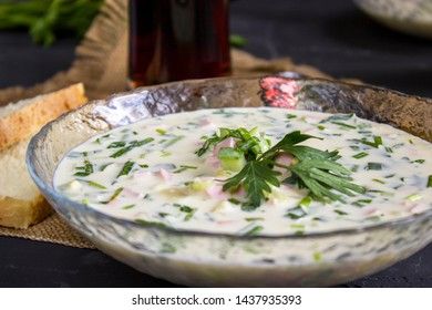 Cold Soup Okroshka. With sausage, vegetables and kvass serving size in bowl and raw ingredients on wooden table