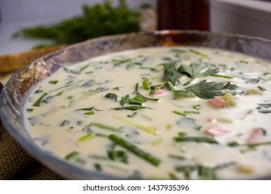 Cold Soup Okroshka. With sausage, vegetables and kvass serving size in bowl and raw ingredients on wooden table