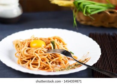 Delicious pasta with egg yolk, on wooden table.