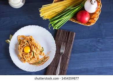Delicious pasta with egg yolk, on wooden table.