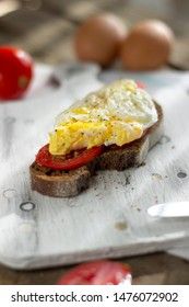 Poached egg on sourdough toast, with grilled tomatoes. A healthy, delicious breakfast or brunch.