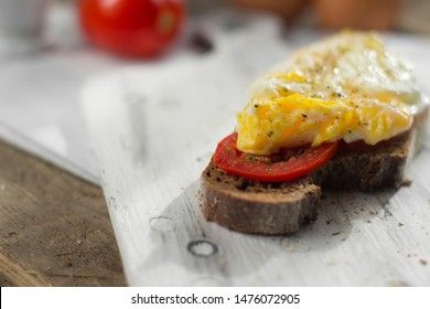 Poached egg on sourdough toast, with grilled tomatoes. A healthy, delicious breakfast or brunch.