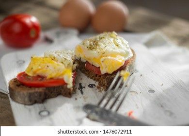 Poached egg on sourdough toast, with grilled tomatoes. A healthy, delicious breakfast or brunch.