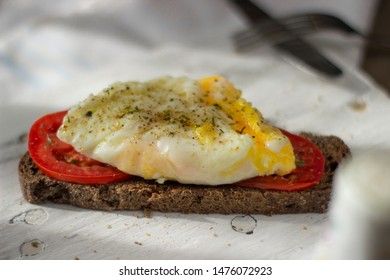 Poached egg on sourdough toast, with grilled tomatoes. A healthy, delicious breakfast or brunch.