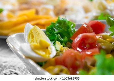 Greek salad with olives, tomatoes, feta cheese, onions in blue bowl on wooden background. Close up. Selective focus.