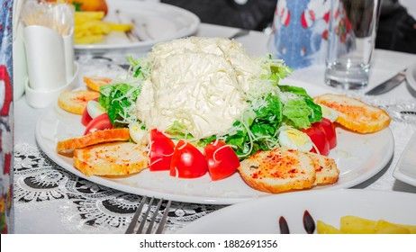 Healthy grilled chicken Caesar salad with tomatoes, cheese and croutons.