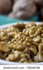 Peeled walnut in a white cup on a wooden background