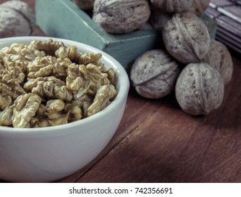 Peeled walnut in a white cup on a wooden background